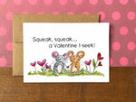 A Valentine's Day note card with an illustration of two mice holding hands and the message "Squeak, squeak...a Valentine I seek!"